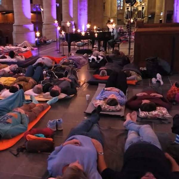 Luchtbedden en gesloten ogen in de Nieuwe Kerk tijdens ligconcert